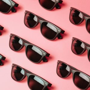 Gafas de sol negras sobre fondo rosa